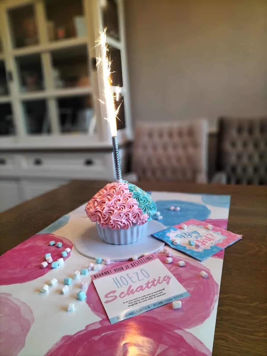 Roze en blauwe cupcake met sterretje, Boy or Girl servetjes en marshmallows op een feestelijk gedekte tafel