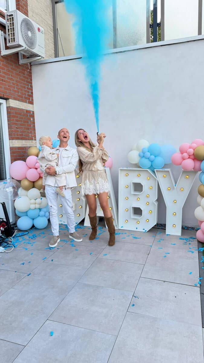 Gezin viert gender reveal thuis met blauwe poeder shooter, BABY-lichtletters en roze-blauwe ballonnen