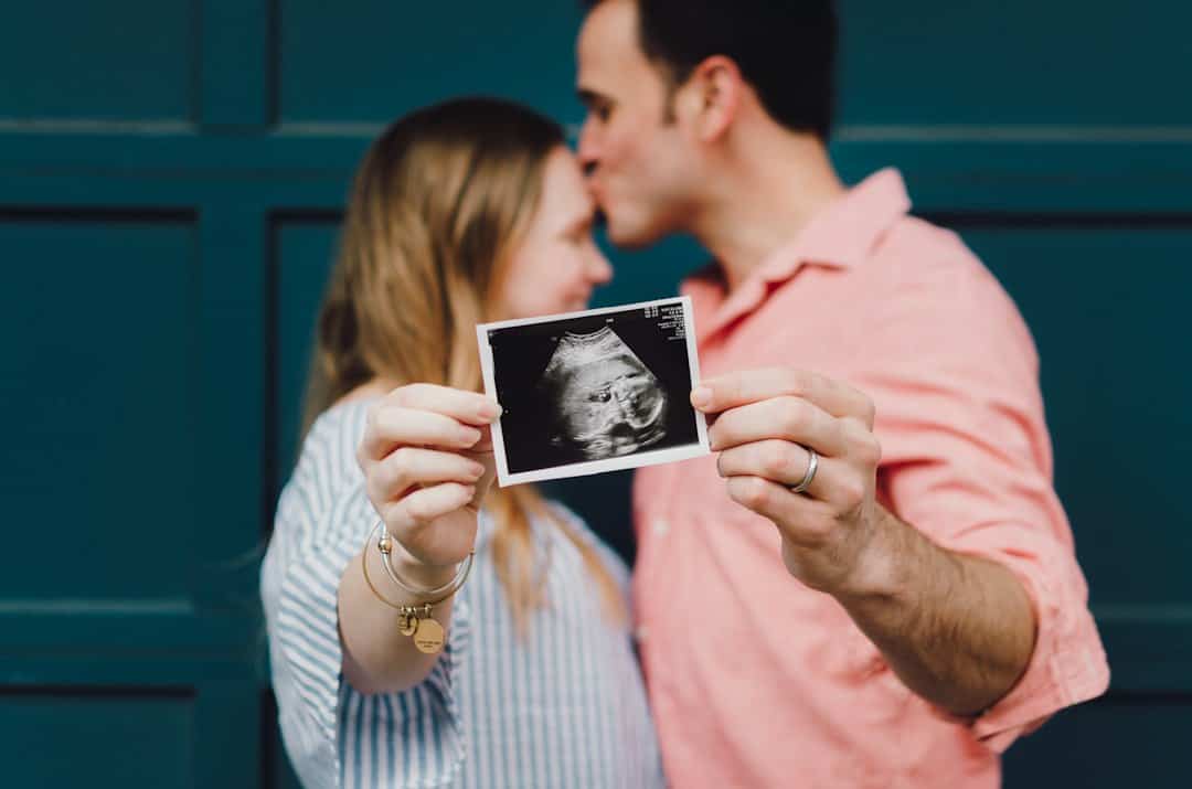Aanstaande ouders houden samen een echofoto van hun baby vast